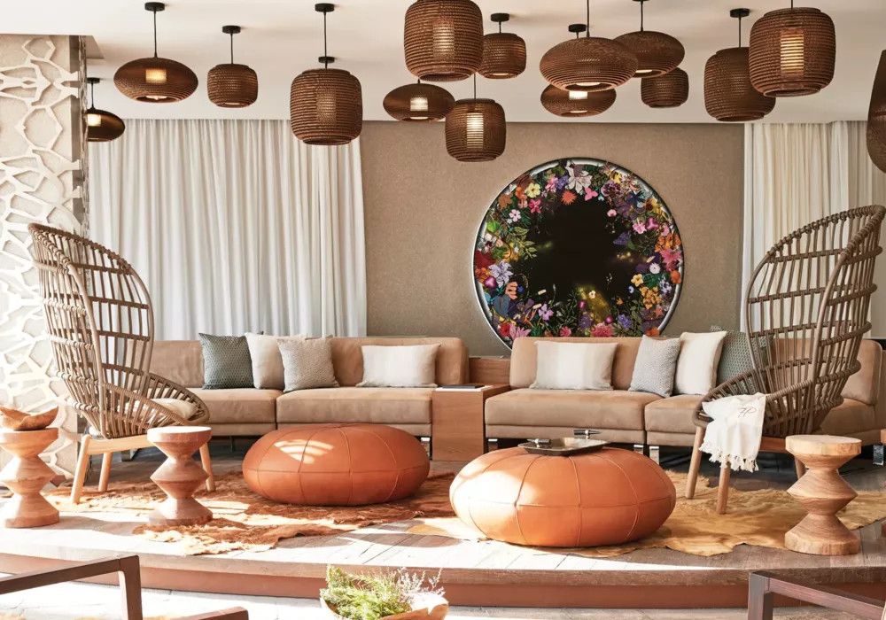 Luxury lounge with modern rattan furniture, leather ottomans, and a stylish wall decoration featuring floral elements at 7Pines Resort Ibiza