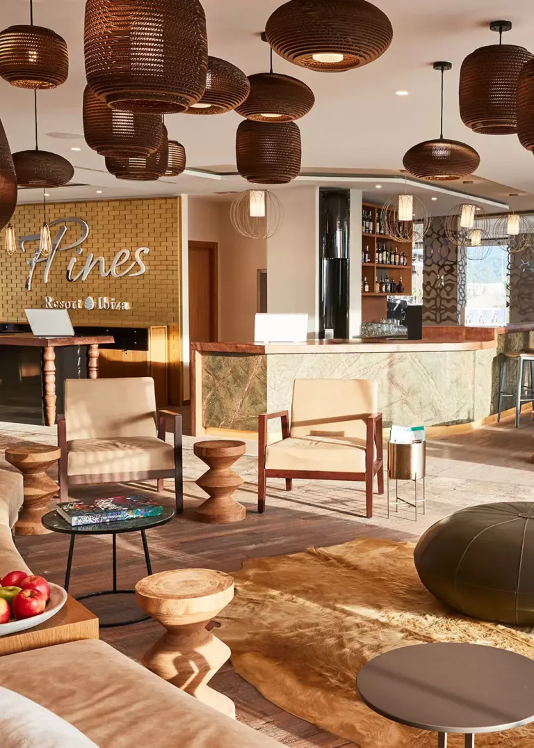 Elegant lobby at 7Pines Resort Ibiza featuring stylish seating, warm wood accents, and a luxurious bar