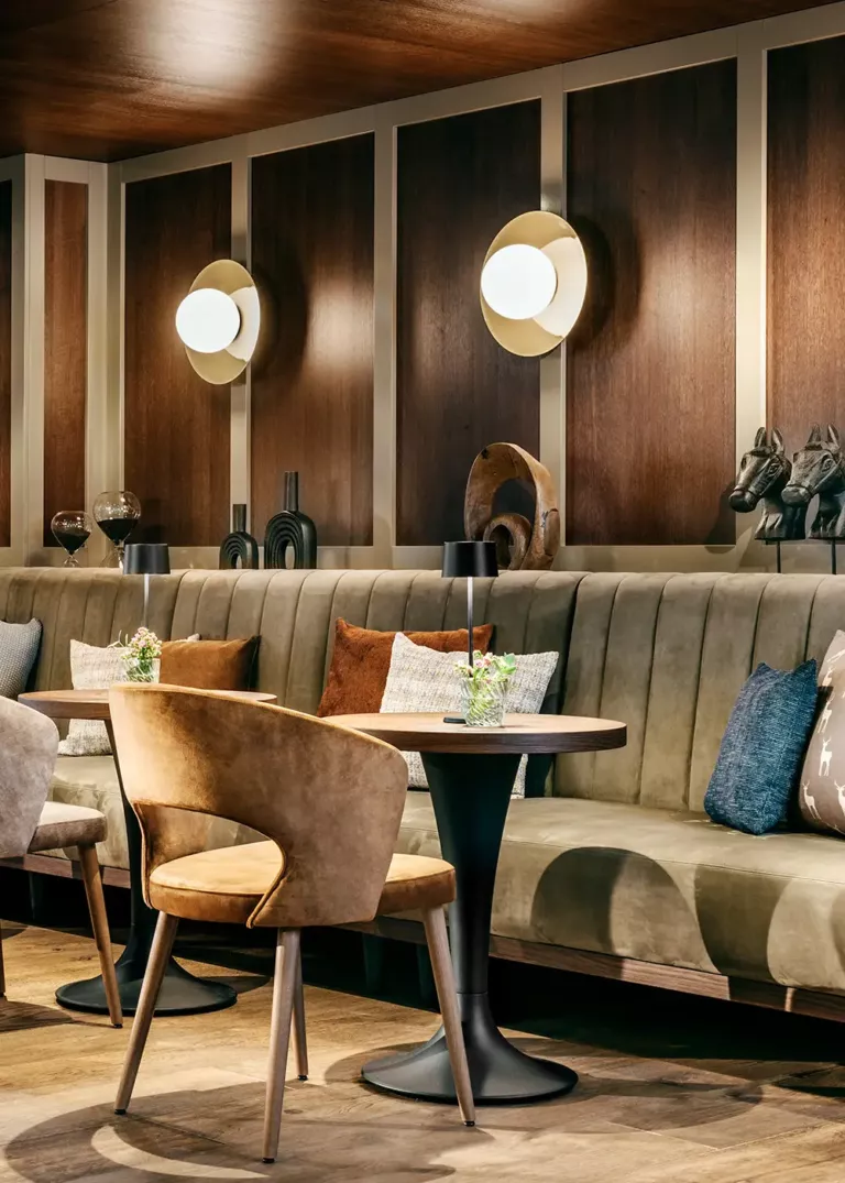 Stylish lounge at Grand Tirolia Kitzbühel featuring an elegant bench, warm wood accents, and cozy lighting