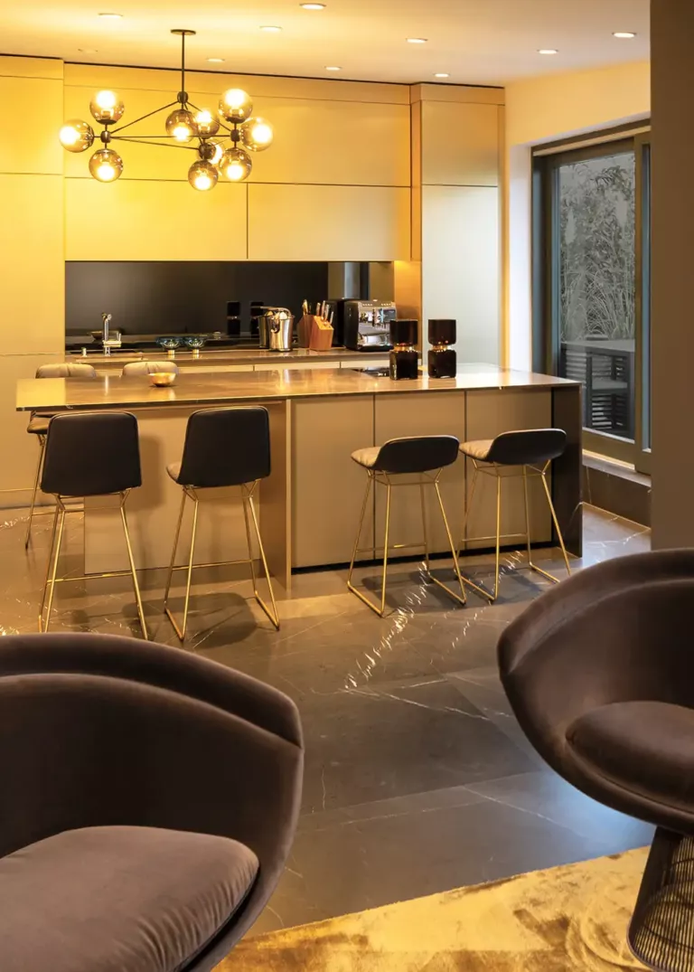 Exclusive designer kitchen in Private Penthouse Berlin featuring gold cabinetry, a sleek kitchen island, and modern bar stools