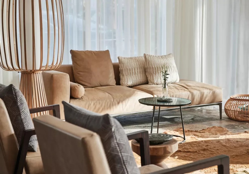 Bright and inviting lounge at 7Pines Resort Ibiza featuring comfortable seating, stylish wood details, and soft natural light