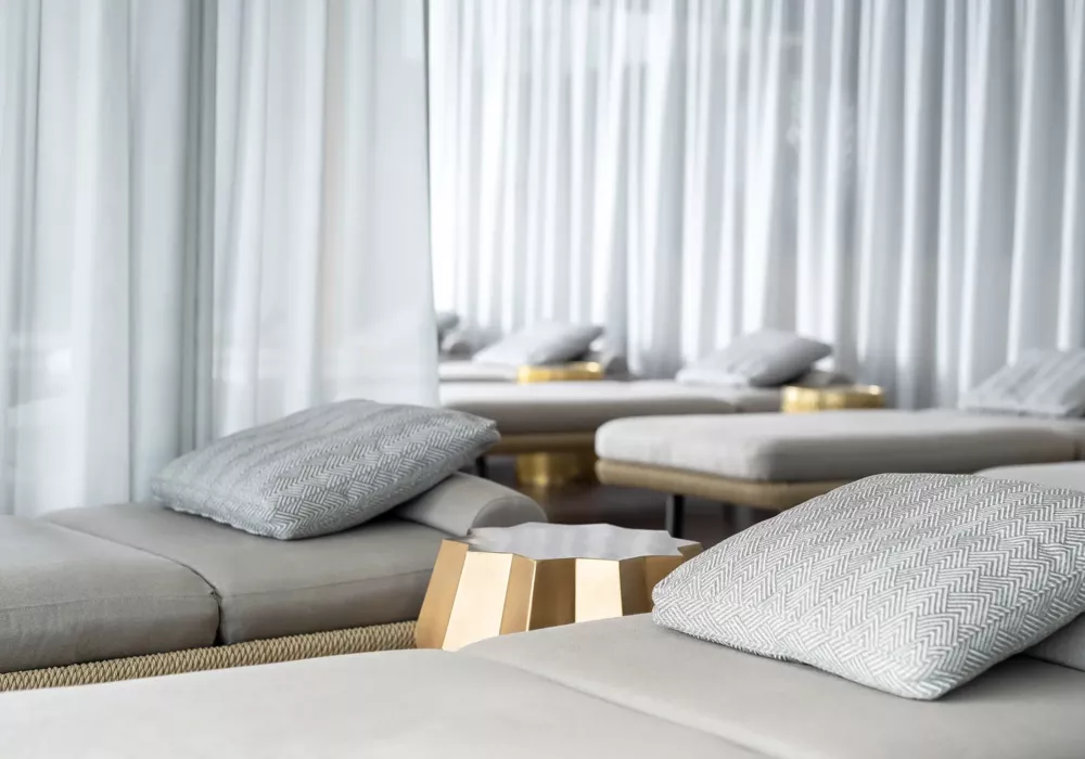Exclusive relaxation area at Ostsee Therme Scharbeutz featuring elegant loungers, stylish cushions, and gold accents