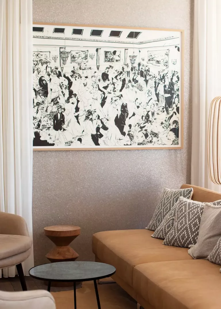 Cozy seating area at 7Pines Resort Ibiza featuring a stylish sofa, decorative cushions, and a large black-and-white artwork on the wall