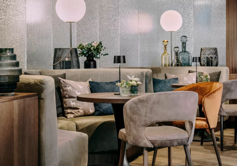 Elegant seating area at Grand Tirolia Kitzbühel featuring stylish upholstered furniture, soft lighting, and decorative accents