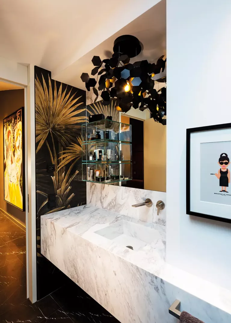 Exclusive bathroom in Private Penthouse Berlin featuring a marble washbasin, artistic wallpaper, and a striking designer light fixture
