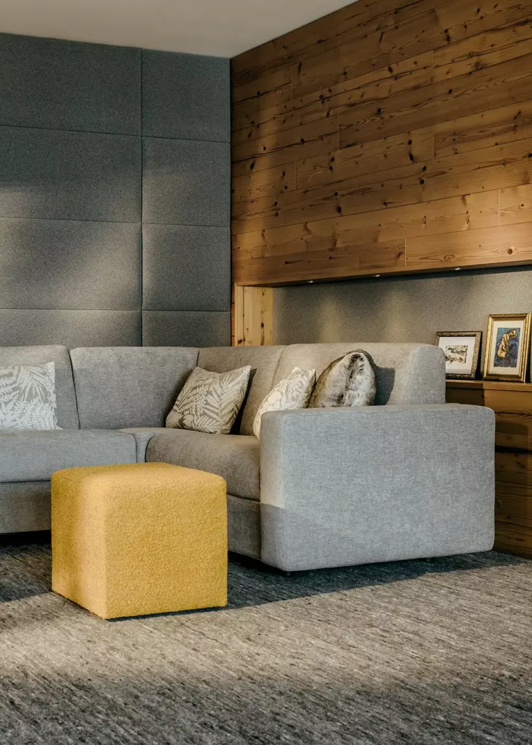 Cozy lounge at Grand Tirolia Kitzbühel featuring a modern corner sofa, wooden accents, and stylish decorative elements