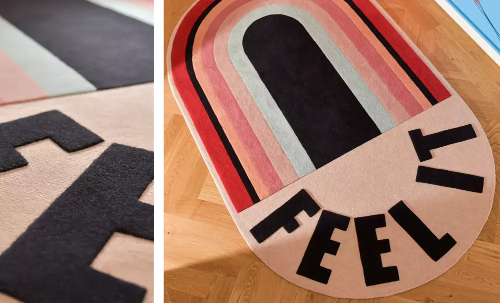  Designer rug with a graphic pattern in red pink and black tones featuring the text FEEL IT accompanied by a close-up of the raised lettering.